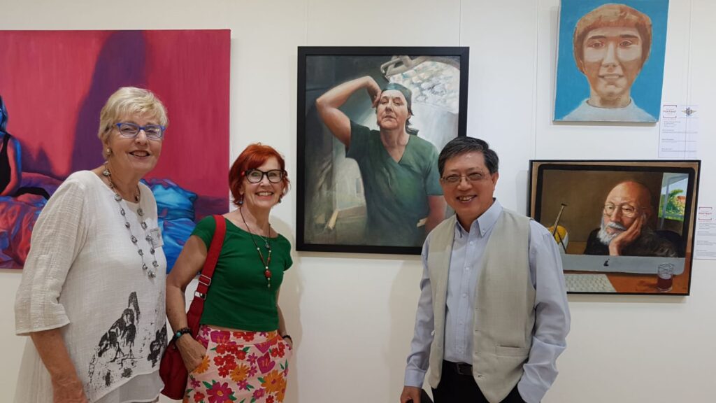 Esteemed members of the Driftwood Art Society stand in awe of their inspiring artwork at an exhibition